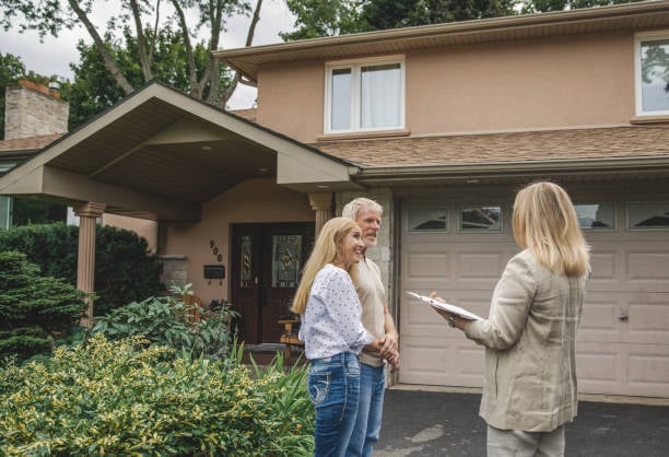 home appraisal - couple in their 50s with a real estate agent looking at their property