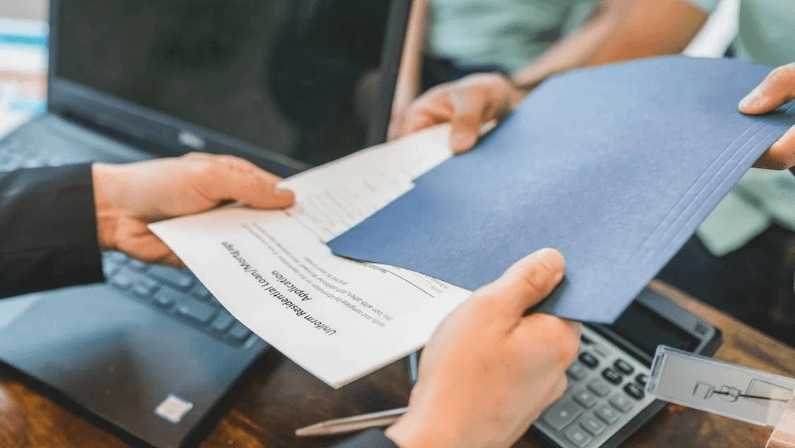 a man is giving a form to fill up for the steps in getting a reverse mortgage