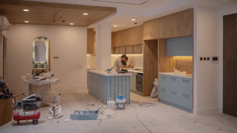 2 men doing house repairs in the kitchen