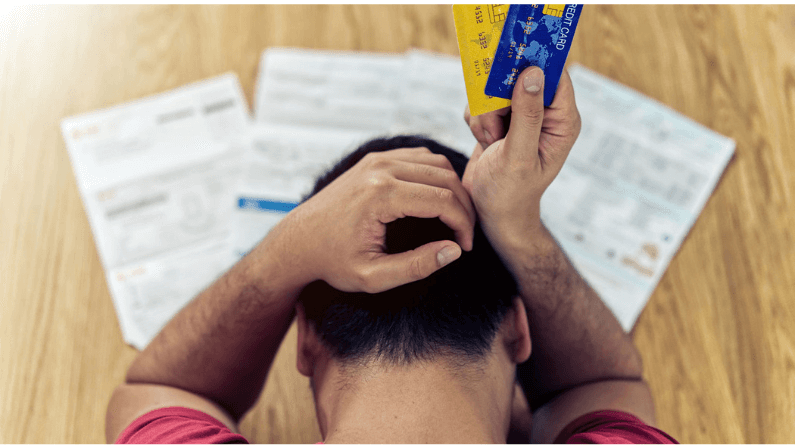 A man stressed about paying his mortgage loan using credit card