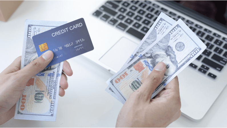 A man ready to pay his mortgage loan using his credit card and cash