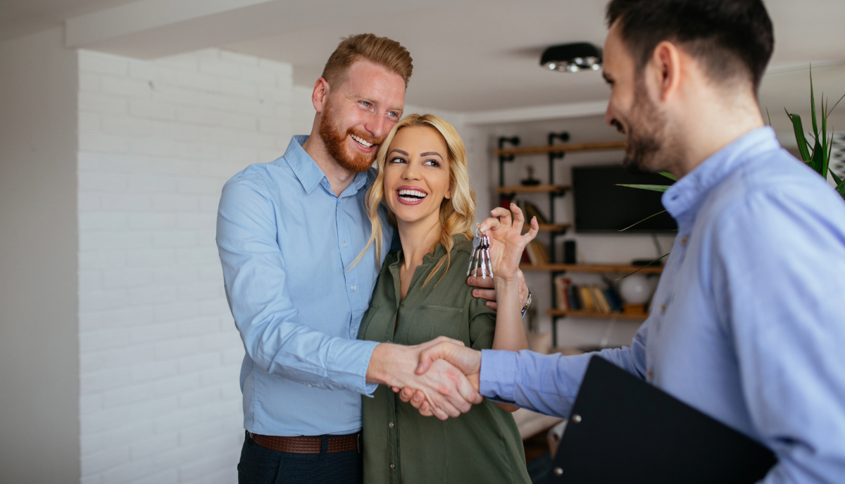 Couple holding house keys with mortgage broker in Oshawa